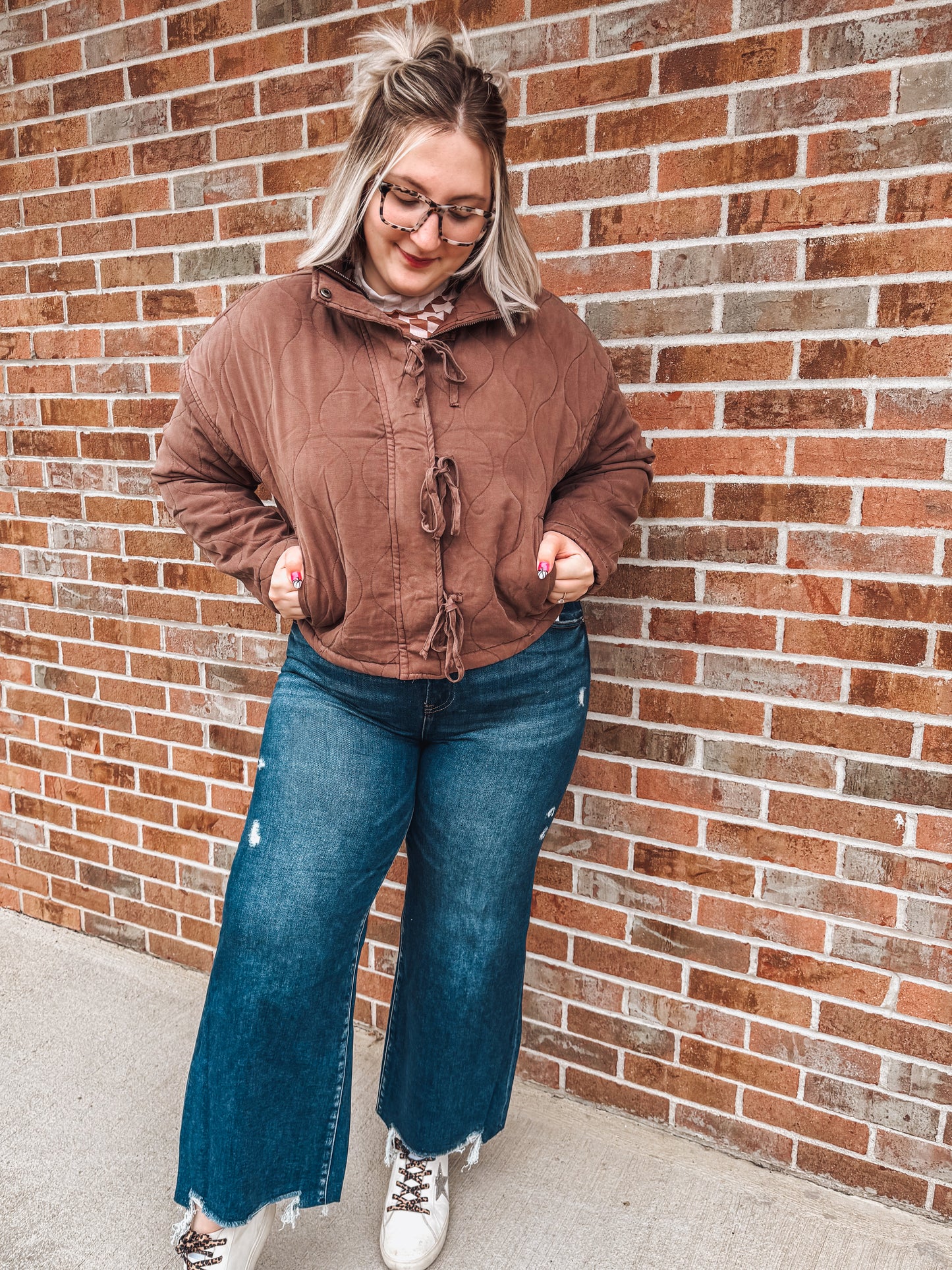 brown quilted jacket with zipper, button and tie details